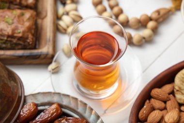 Hafif ahşap arka planda Ramazan için bir fincan çay ve geleneksel Doğu tatlıları, yakın plan