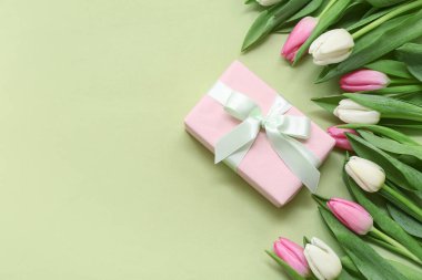 Pembe hediye kutusu ve yeşil arka planda güzel laleler. Uluslararası Kadınlar Günü