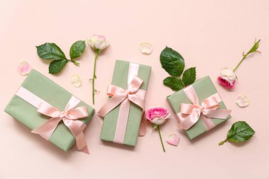 Yeşil hediye kutuları ve pembe arka planda güzel güller. Uluslararası Kadınlar Günü