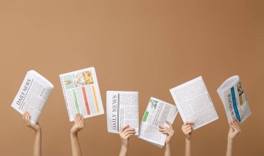 Kahverengi arka planda gazeteleri olan kadınlar