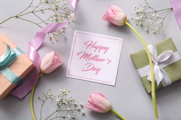 Карточка с текстом День Матери, подарочные коробки и красивые цветы на светлом фоне
