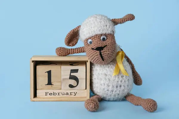 金丝带和蓝色背景日历的玩具羊 儿童癌症意识概念 — 图库照片