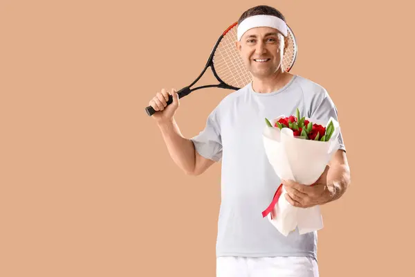 Mann Mittleren Alters Sportkleidung Mit Blumenstrauß Und Tennisschläger Auf Beigem — Stockfoto