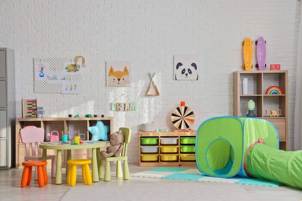 Interior of playroom with shelves and toys in kindergarten