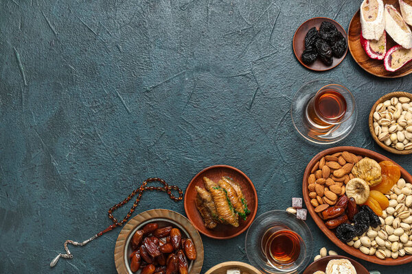 Композиция с традиционными восточными сладостями, чай и тасби для Рамадана на темном фоне