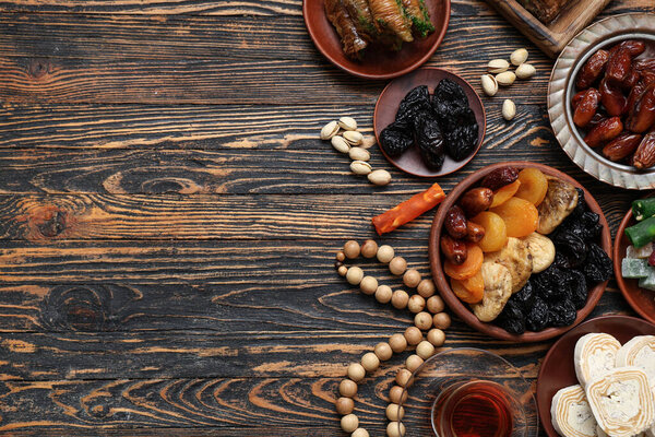 Композиция с традиционными восточными сладостями и тасби для Рамадана на деревянном фоне