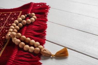 Beyaz ahşap arka planda Ramazan için dua ve boncuklar