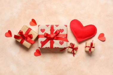 Bej arka planda hediye kutuları ve kumaş kalp. Sevgililer Günü kutlaması