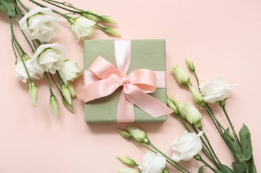 Hediye kutusu ve pembe arka planda güzel beyaz Eustoma çiçekleri. Uluslararası Kadınlar Günü