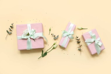 Güzel Eustoma çiçekleriyle hediye kutuları ve sarı arka planda okaliptüs. Uluslararası Kadınlar Günü