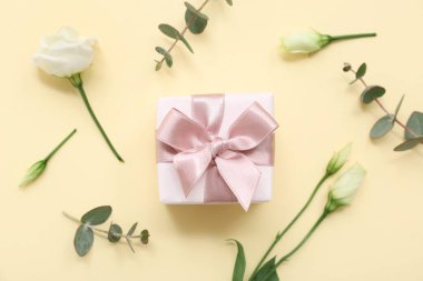 Güzel Eustoma çiçekleri ve sarı arka planda okaliptüs olan hediye kutusu. Uluslararası Kadınlar Günü