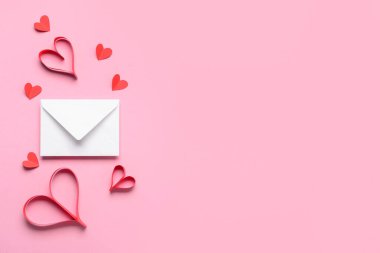 Üzerinde kağıt kalpler ve zarf olan kompozisyon pembe arka planda Sevgililer Günü kutlaması