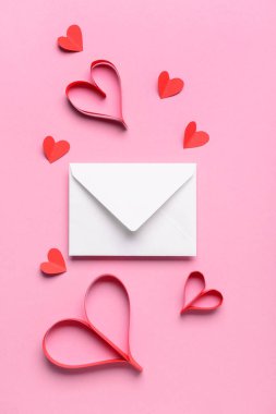 Üzerinde kağıt kalpler ve zarf olan kompozisyon pembe arka planda Sevgililer Günü kutlaması