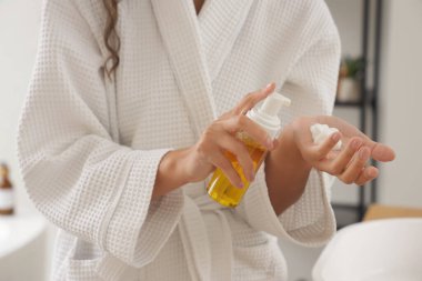 Banyoda köpük temizleyen genç bir kadın, yakın plan.