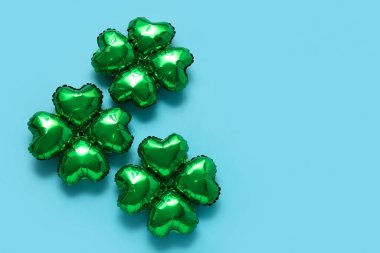 Mavi arka planda yonca şeklinde balonlar. Aziz Patrick Günü kutlaması