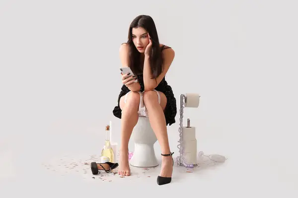 Mujer Joven Borracha Usando Teléfono Móvil Inodoro Contra Fondo Claro — Foto de Stock