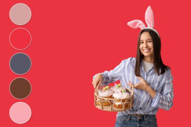 Tavşan kulaklı güzel bir bayan ve kırmızı arka planda pastaları olan Paskalya sepeti. Farklı renk desenleri