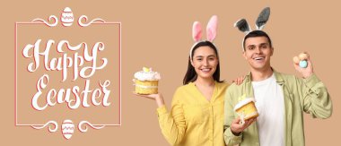 Tavşan kulaklı mutlu genç çift, bej arka planda paskalya yumurtası ve kekler. Paskalya bayrağı