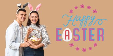 Tavşan kulaklı mutlu genç çift ve bej arka planda Paskalya sepeti. Paskalya bayrağı