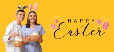 Tavşan kulaklı mutlu genç çift ve sarı arka planda Paskalya sepetleri. Paskalya bayrağı