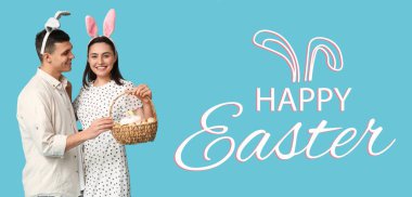 Tavşan kulaklı mutlu genç çift ve açık mavi arka planda Paskalya sepeti. Paskalya bayrağı