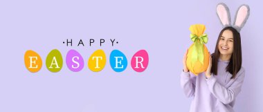 Leylak arka planında hediye ve tavşan kulaklı genç bir kadın. Paskalya bayrağı