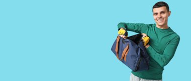 Mavi arka planda spor çantalı genç adam mesaj için yer var.