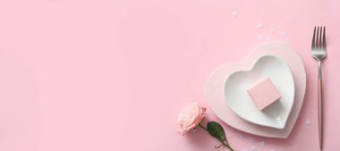 Sevgililer Günü yemeği için güzel bir masa. Pembe arka planda. Mesaj için yer var.