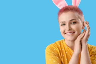 Mavi arka planda tavşan kulaklı genç bayan, yakın plan. Paskalya kutlaması