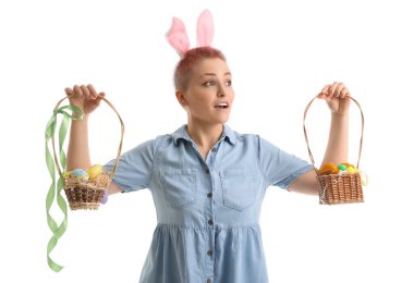 Tavşan kulaklı ve beyaz arka planda Paskalya yumurtası sepetleri olan genç bir kadın.