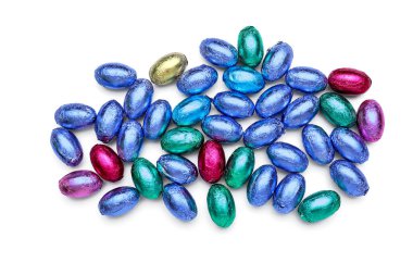 Beyaz arka planda folyoya sarılı bir yığın çikolata Paskalya yumurtası.