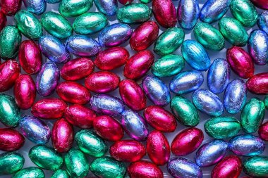 Çikolata yığını Paskalya yumurtaları renkli folyolar, yakın plan.