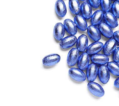 Beyaz arka planda renkli folyoyla tatlı Paskalya yumurtaları