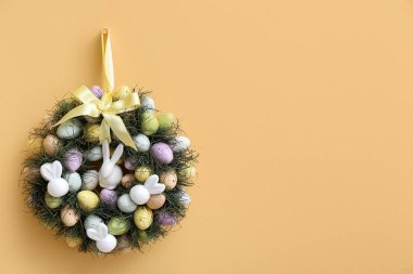 Sarı duvarda asılı Paskalya çelengi