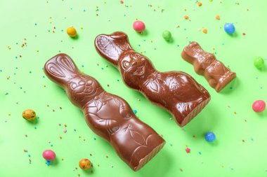 Çikolatalı Paskalya tavşanı. Yeşil arka planda şekerleme ve şekerleme var.