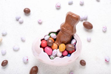 Beyaz arka planda yumurtaları olan Paskalya tavşanı, yakın plan.