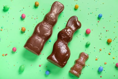 Çikolatalı Paskalya tavşanı. Yeşil arka planda şekerleme ve şekerleme var.