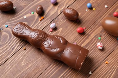 Çikolatalı Paskalya tavşanı. Tahta arka planda yumurtalar ve serpiştirilmiş.