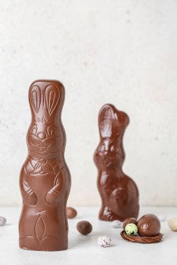 Beyaz arka planda yumurtaları olan Paskalya tavşanları.