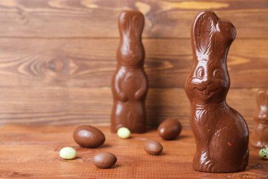 Tahta arka planda yumurtaları olan Paskalya tavşanları, yakın plan.