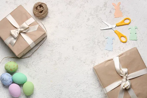 Frame made of gifts, Easter eggs, scissors and rope on grunge background