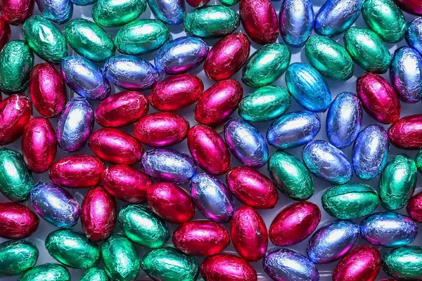 Çikolata yığını Paskalya yumurtaları renkli folyolar, yakın plan.