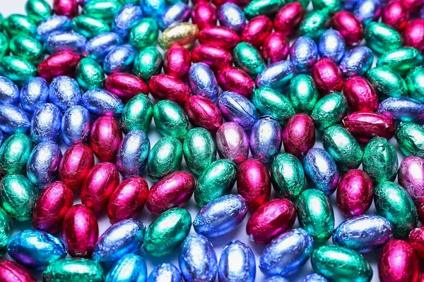 Çikolata yığını Paskalya yumurtaları renkli folyolar, yakın plan.