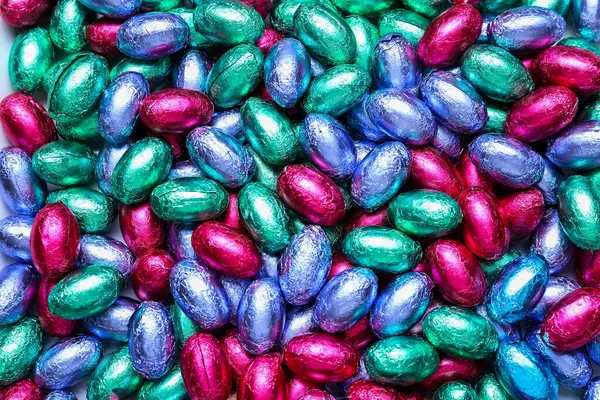 Çikolata yığını Paskalya yumurtaları renkli folyolar, yakın plan.