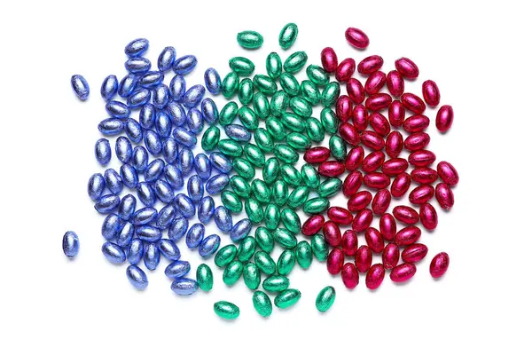 Beyaz arka planda renkli folyoya sarılı çikolatalı Paskalya yumurtaları.