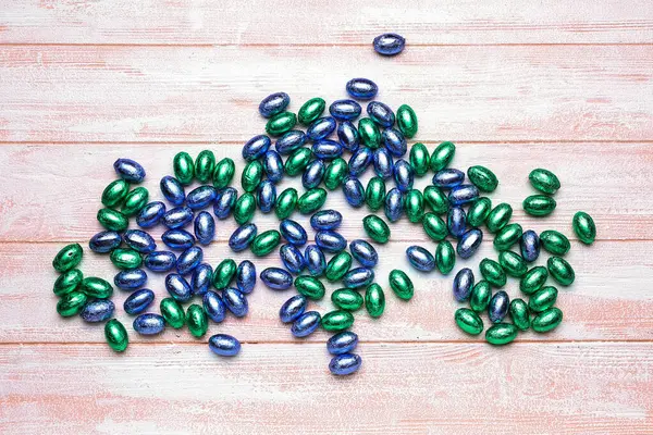 Hafif ahşap arka planda bir yığın çikolata Paskalya yumurtası.