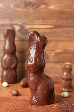 Tahta arka planda yumurtaları olan Paskalya tavşanları, yakın plan.