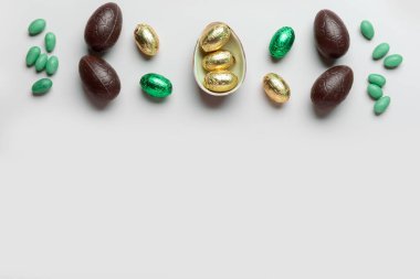 Tatlı çikolatalı Paskalya yumurtaları ve hafif arka planda şekerler