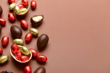 Kahverengi arka planda çikolatalı Paskalya yumurtası ve şekeri.