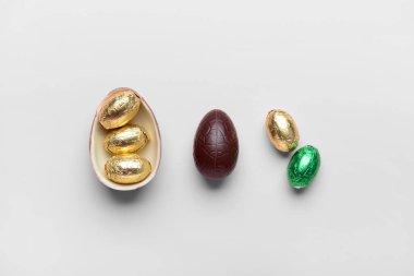 Tatlı çikolatalı Paskalya yumurtaları ve hafif arka planda şekerler